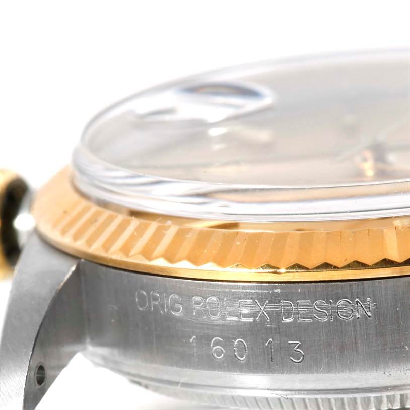 This image shows a close-up of the side of a Rolex Datejust 16013 Men's Stainless Steel Champagne Dial 16013 Men's Stainless Steel Champagne Dial watch, focusing on the bezel and engraving on the case.