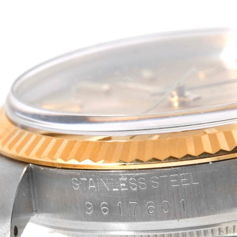 The image shows a close-up of the Rolex Datejust 16013 Men's Stainless Steel Champagne Dial 16013 Men's Stainless Steel Champagne Dial watch, displaying part of the bezel, crystal, and case with the serial number.