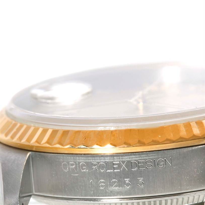 The image shows a close-up side view of a Rolex Datejust 16233 Men's Steel and Gold (two tone) Champagne Dial 16233 Men's Steel and Gold (two tone) Champagne Dial model, highlighting the bezel and part of the case with engraving.