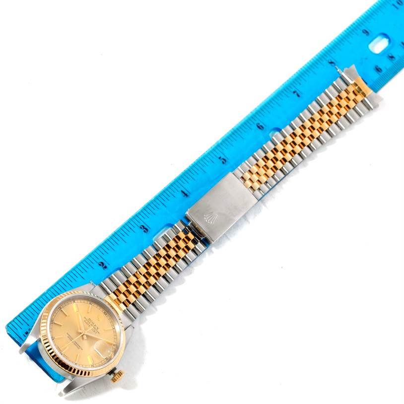 The image shows a Rolex Datejust 16233 Men's Steel and Gold (two tone) Champagne Dial 16233 Men's Steel and Gold (two tone) Champagne Dial watch at a top-down angle, focusing on the entire watch band and the face, with a ruler aligning with it.