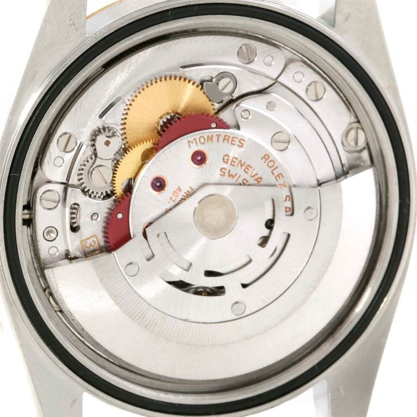 The image shows the internal mechanism of the Rolex Datejust 16233 Men's Steel and Gold (two tone) Champagne Dial 16233 Men's Steel and Gold (two tone) Champagne Dial watch, revealing its gears, movement, and rotor.