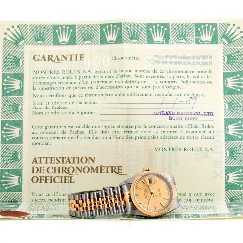 The Rolex Datejust 16233 Men's Steel and Gold (two tone) Champagne Dial 16233 Men's Steel and Gold (two tone) Champagne Dial watch is angled face-up and placed atop its official certification document.