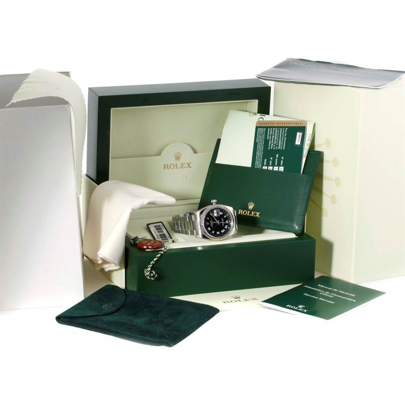 The image shows a Rolex Datejust 115234 Men
s Stainless Steel Black Dial 115234 Men
s Stainless Steel Black Dial watch with its original box, warranty card, booklet, tags, and cleaning cloth.