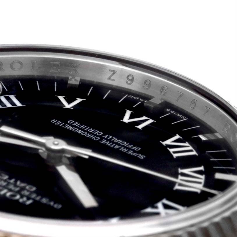 This image shows a close-up angle of the Rolex Datejust 115234 Men
s Stainless Steel Black Dial 115234 Men
s Stainless Steel Black Dial watch, focusing on its dial, hands, and part of the bezel with engraved markings.