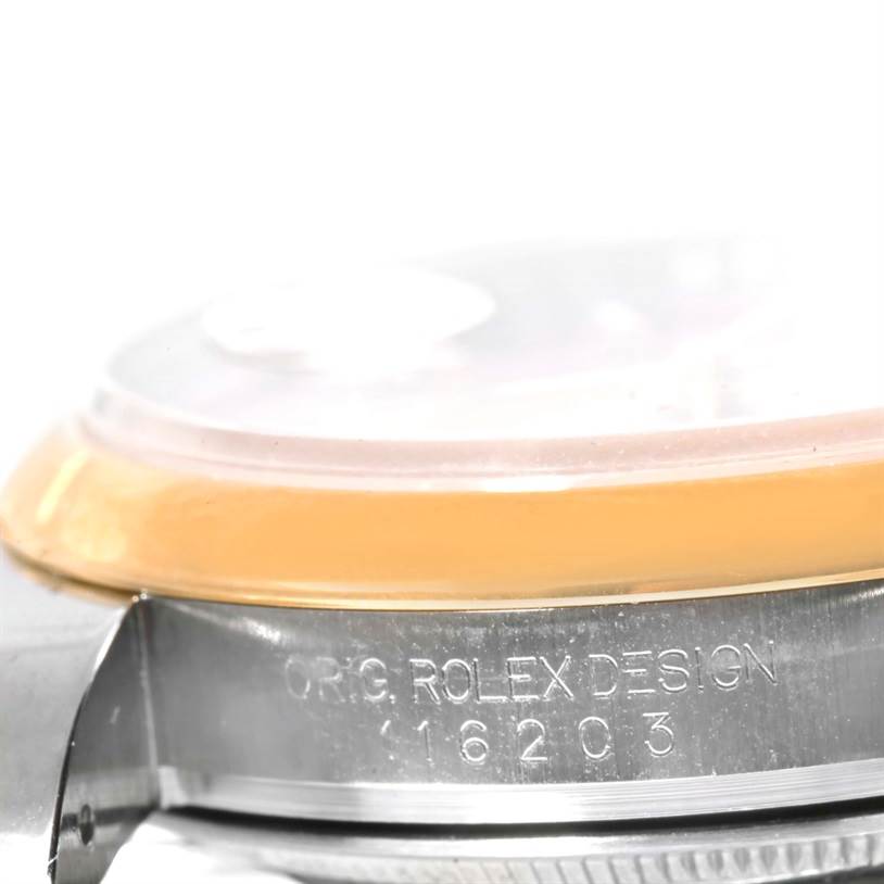 The image shows a close-up side view of a Rolex Datejust 116203 Men
s Stainless Steel Champagne Dial 116203 Men
s Stainless Steel Champagne Dial watch, focusing on the engraved model number and part of the crystal.