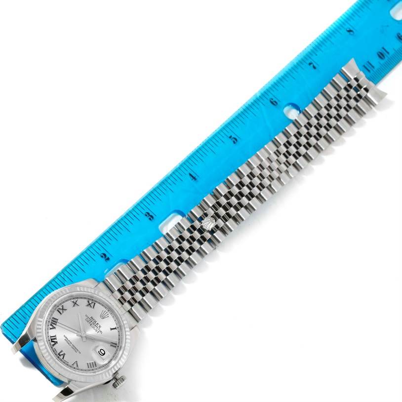 The image shows a Rolex Datejust 116234 Men's Stainless Steel Silver Dial 116234 Men's Stainless Steel Silver Dial watch face and its metal bracelet measured with a blue ruler for length.