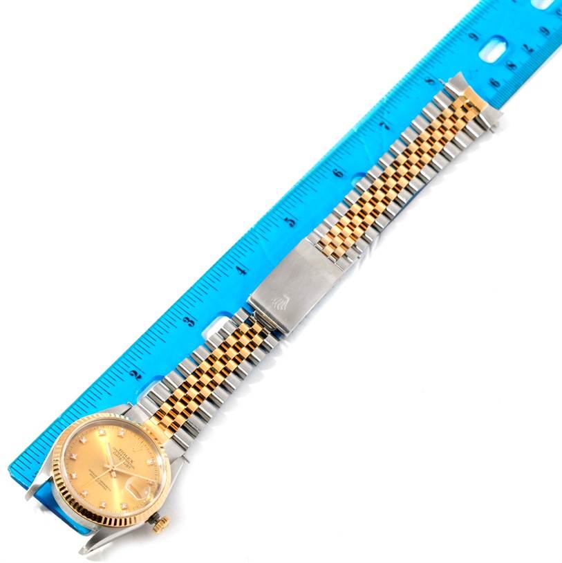 This image displays a fully extended Rolex Datejust 16233 Men's Steel and Gold (two tone) Champagne Dial 16233 Men's Steel and Gold (two tone) Champagne Dial watch in a top-down angle, alongside a blue ruler for measurement.