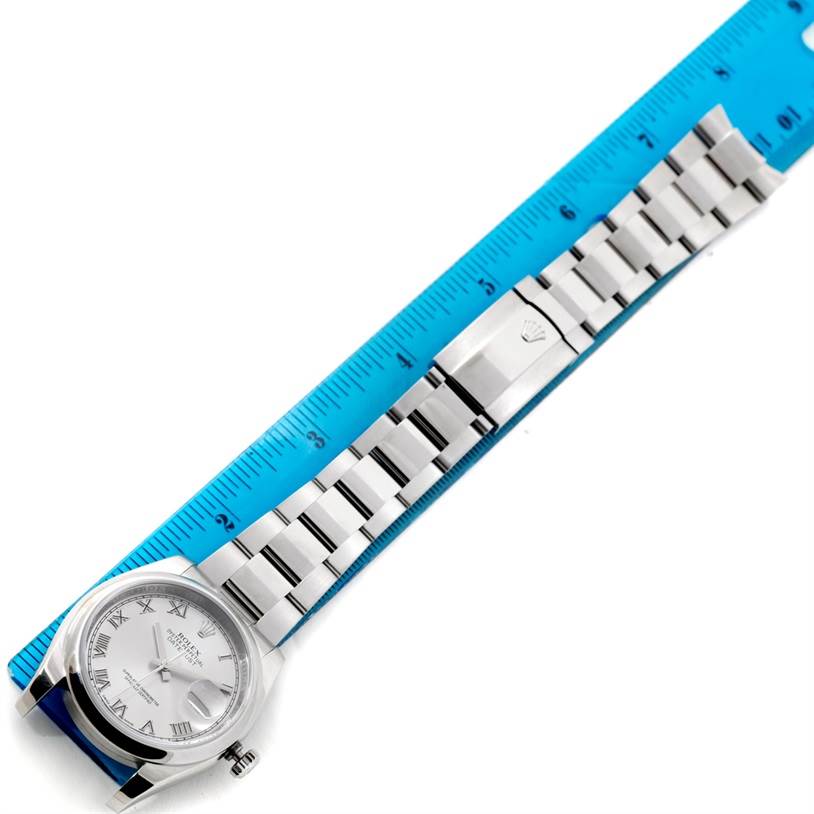 The image shows a horizontally oriented Rolex Datejust 116200 Men
s Stainless Steel Grey Dial 116200 Men
s Stainless Steel Grey Dial watch with a silver bracelet and a blue measuring scale.