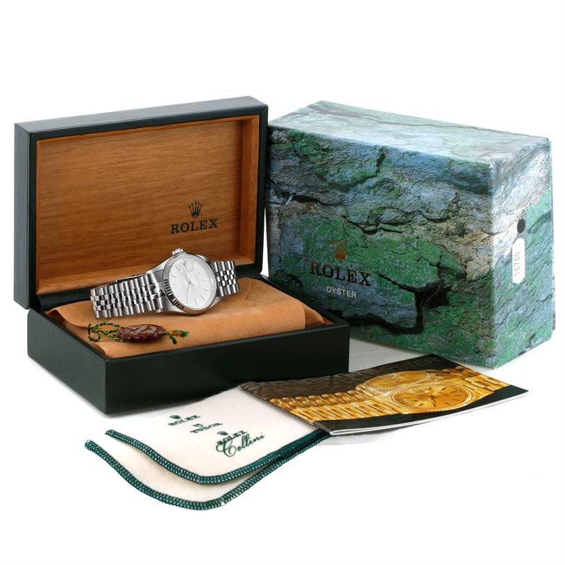 The Rolex Datejust 16234 Men's Stainless Steel Silver Dial 16234 Men's Stainless Steel Silver Dial watch is displayed in an open box with accessories, including cloths and booklets, visible from a front angle.