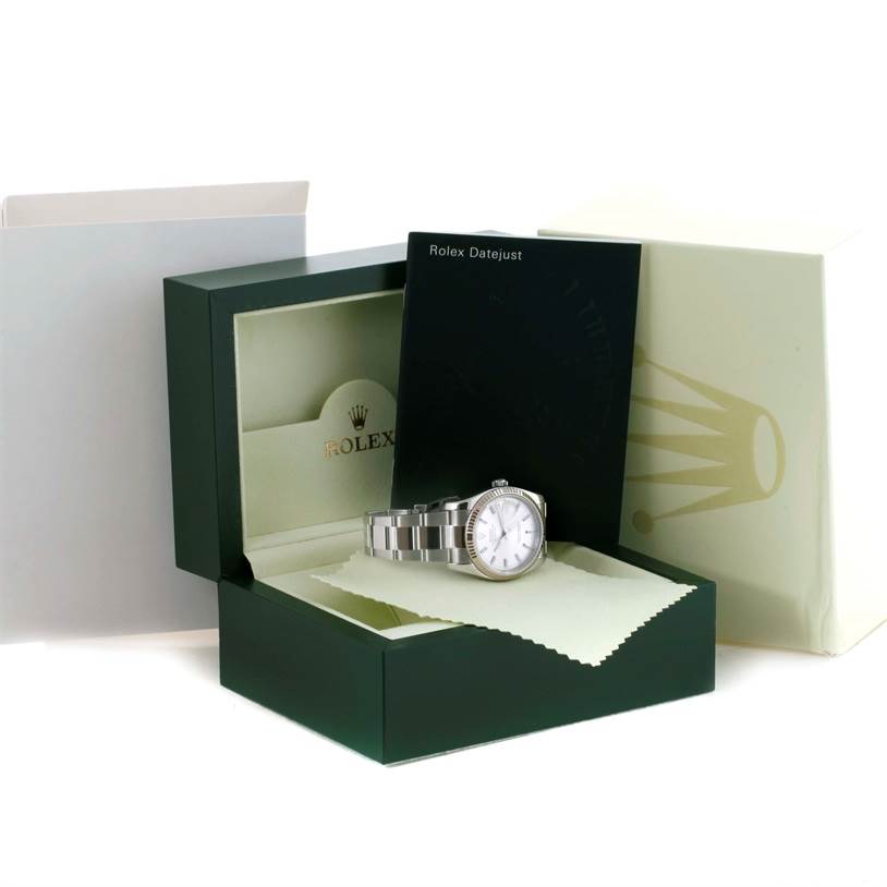 The Rolex Datejust 116234 Men's Stainless Steel Silver Dial 116234 Men's Stainless Steel Silver Dial watch is shown at an angle inside its green box, alongside its manual and packaging accessories.