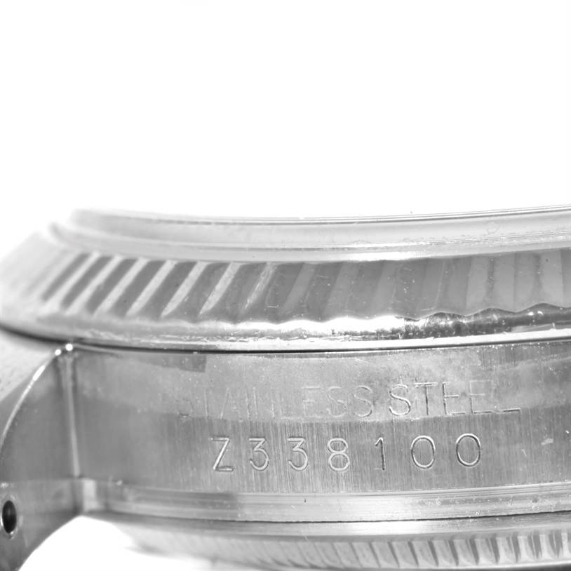 The image shows a side view of the Rolex Datejust 116234 Men
s Stainless Steel Black Dial 116234 Men
s Stainless Steel Black Dial model, highlighting part of its fluted bezel and case with the serial number.