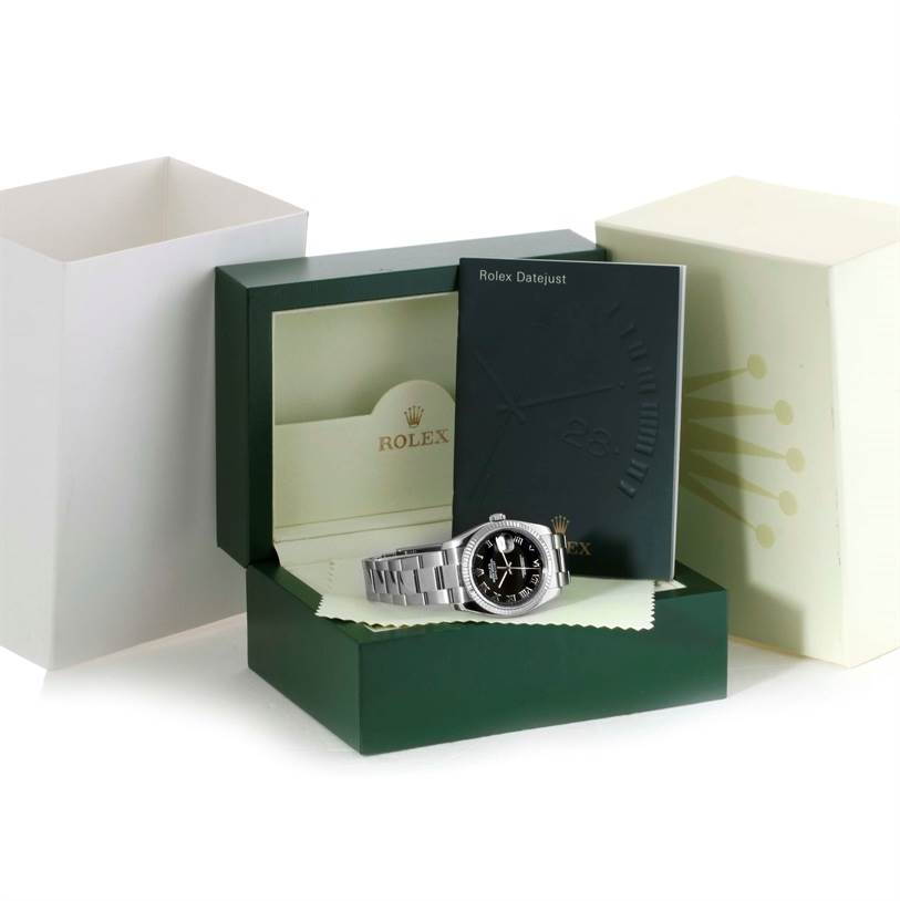 The image shows a Rolex Datejust 116234 Men
s Stainless Steel Black Dial 116234 Men
s Stainless Steel Black Dial watch with its green box, white box sleeve, and instruction manual at an angled view.