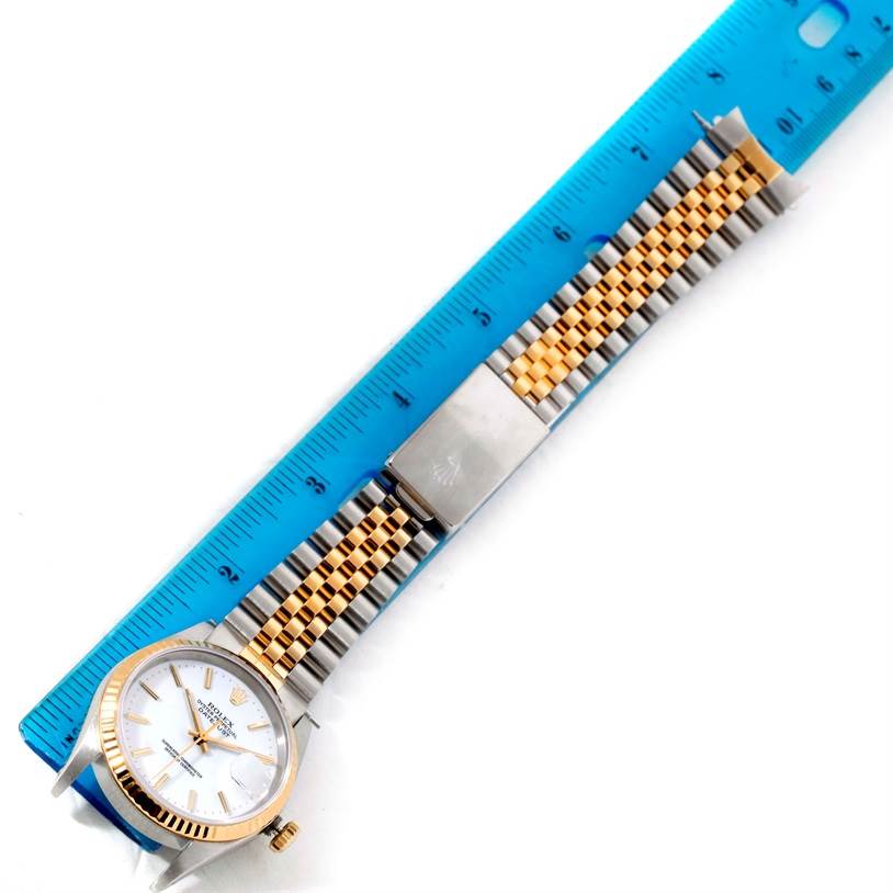 The image shows the Rolex Datejust 16233 Men
s Steel and Gold (two tone) White Dial 16233 Men
s Steel and Gold (two tone) White Dial watch placed next to a ruler, displaying its face, case, and two-tone metal bracelet.