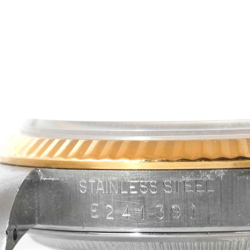 The image shows the side view of the case and bezel of a Rolex Datejust 16233 Men
s Steel and Gold (two tone) Silver Dial 16233 Men
s Steel and Gold (two tone) Silver Dial watch, highlighting its stainless steel part and serial number.