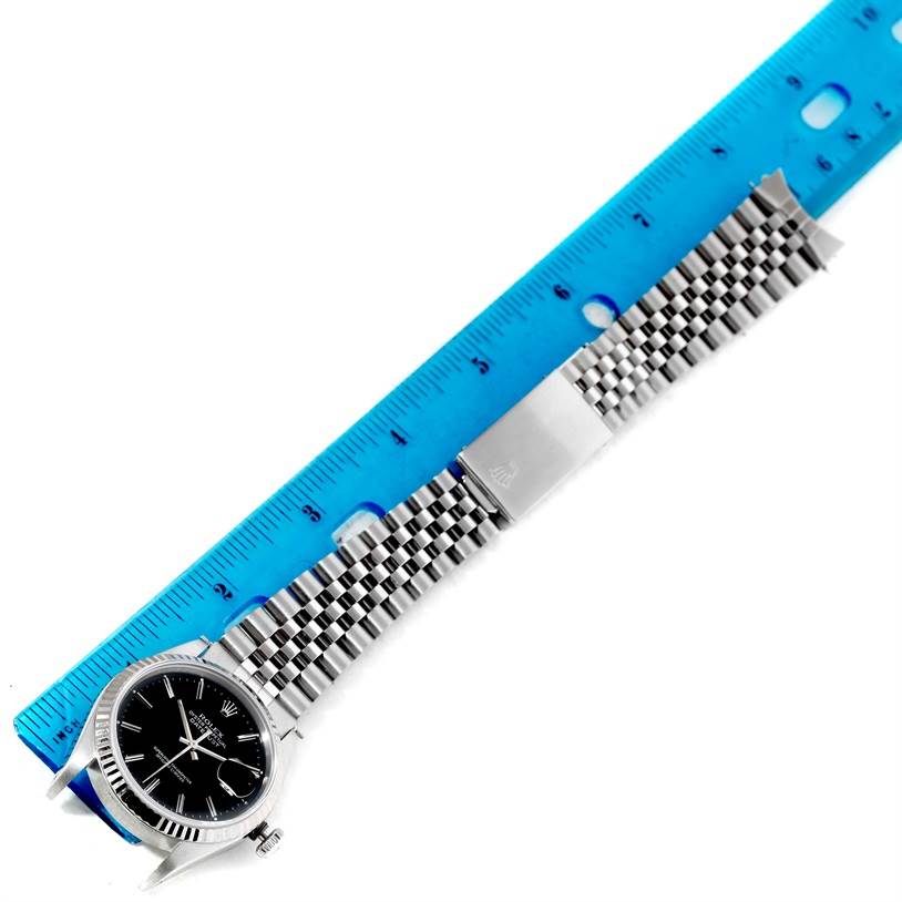 The image shows a top-down view of a Rolex Datejust 16234 Men's Stainless Steel Silver Dial 16234 Men's Stainless Steel Silver Dial watch and its metal bracelet next to a blue ruler for scale.