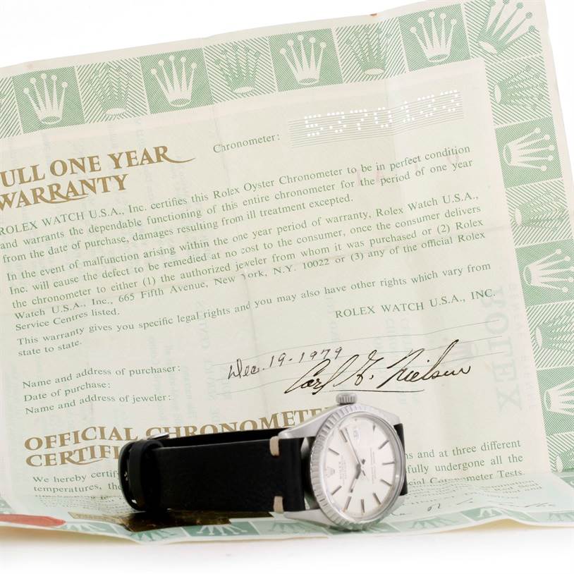 The image shows a Rolex Datejust 1603 Men's Stainless Steel Silver Dial 1603 Men's Stainless Steel Silver Dial watch from a side angle with the full one-year warranty document in the background.