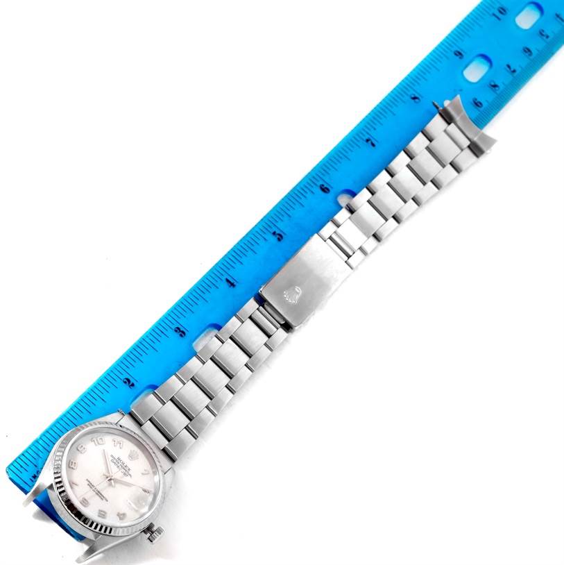 The image shows the Rolex Datejust 16234 Men's Stainless Steel Silver Dial 16234 Men's Stainless Steel Silver Dial watch with its full metal band and clasp, positioned next to a blue ruler.