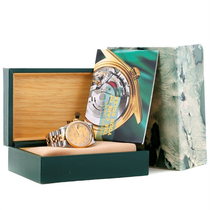 The Rolex Datejust 16233 Men's Steel and Gold (two tone) Champagne Dial 16233 Men's Steel and Gold (two tone) Champagne Dial watch is shown in its open box, along with a booklet and outer packaging.