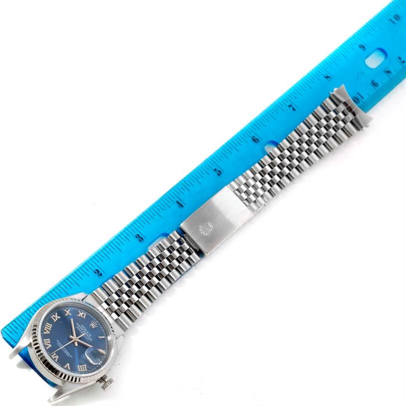 The Rolex Datejust 16234 Men's Stainless Steel Blue Dial 16234 Men's Stainless Steel Blue Dial watch's face and full metal bracelet are shown, laid flat next to a ruler for measurement.