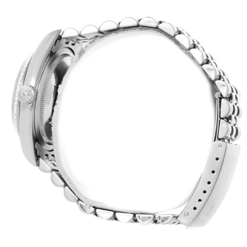 This side view of a Rolex Datejust 16234 Men's Stainless Steel Blue Dial 16234 Men's Stainless Steel Blue Dial watch focuses on its case, winder, bezel, and a portion of its bracelet with clasp.