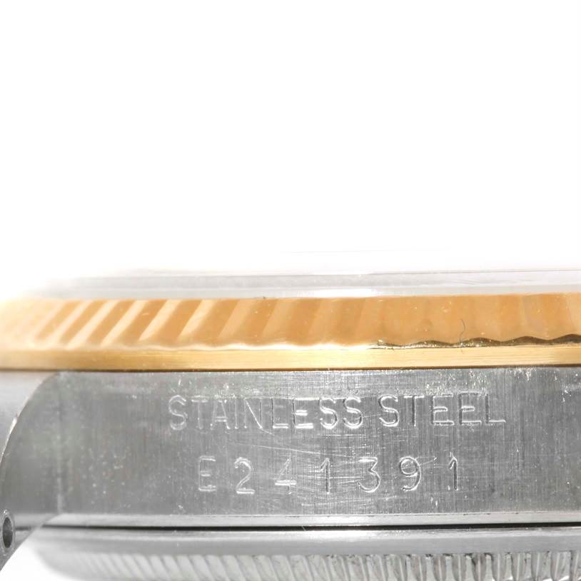 The image shows a close-up of the side view of a Rolex Datejust 16233 Men's Steel and Gold (two tone) Silver Dial 16233 Men's Steel and Gold (two tone) Silver Dial watch, highlighting the stainless steel case and bezel with its serial number.
