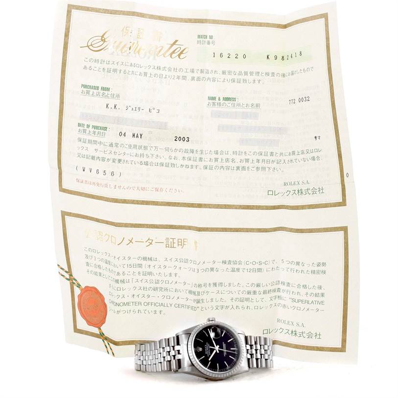 The image shows a Rolex Datejust 16220 Men
s Stainless Steel Black Dial 16220 Men
s Stainless Steel Black Dial watch lying flat with its warranty papers displayed in the background.