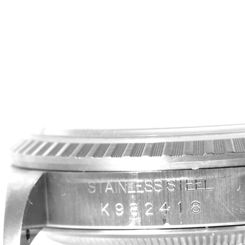 The image shows the side view of a Rolex Datejust 16220 Men
s Stainless Steel Black Dial 16220 Men
s Stainless Steel Black Dial watch, highlighting the stainless steel case and the serial number engraving.