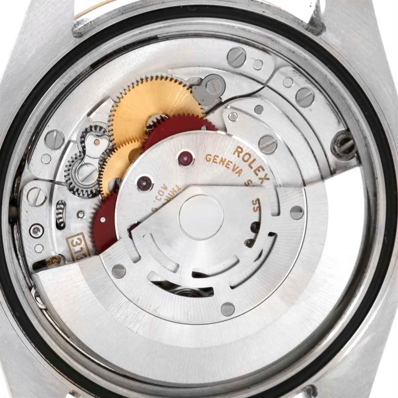 The image shows a close-up of the movement of a Rolex Datejust 116233 Men's Stainless Steel Champagne Dial 116233 Men's Stainless Steel Champagne Dial watch, focusing on its mechanical components.