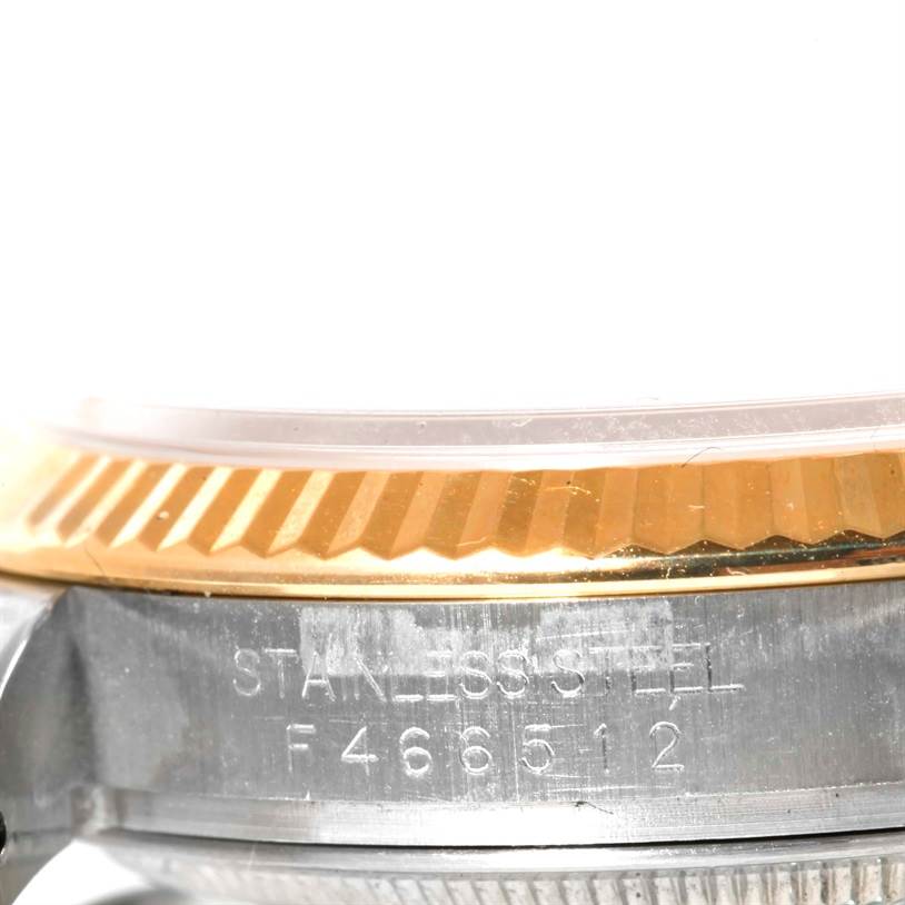This image shows a close-up of the side of a Rolex Datejust 116233 Men's Stainless Steel Champagne Dial 116233 Men's Stainless Steel Champagne Dial watch, highlighting the stainless steel case and the gold bezel.