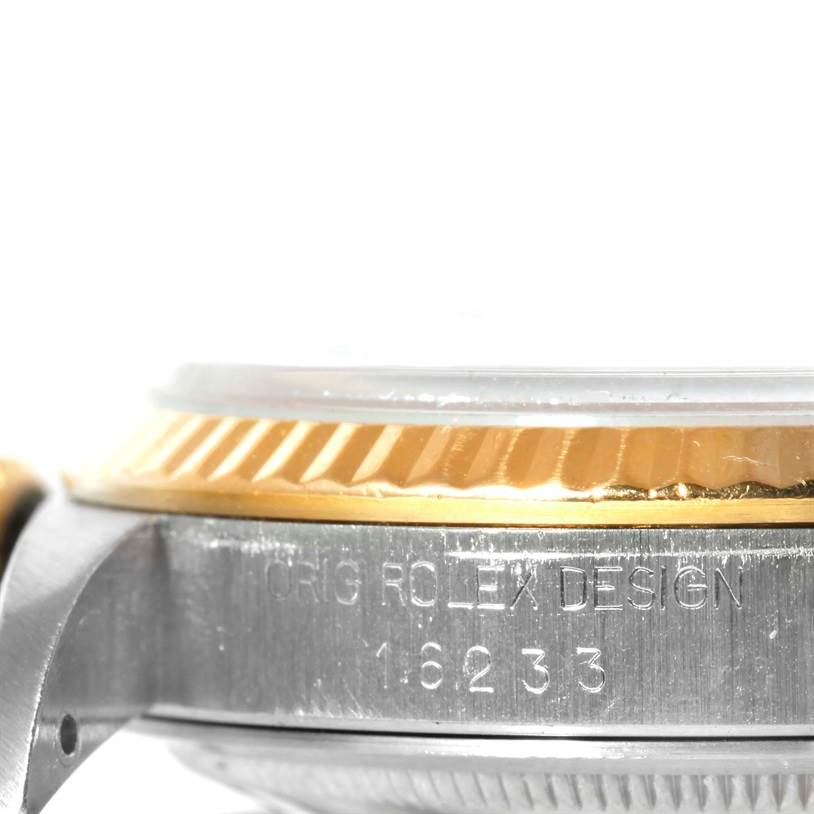 This is a close-up side view of a Rolex Datejust 16233 Men's Steel and Gold (two tone) White Dial 16233 Men's Steel and Gold (two tone) White Dial model, showing the case and bezel with engraved markings.