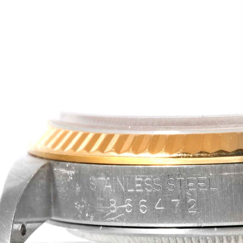 This close-up shows the side profile of a Rolex Datejust 16233 Men's Steel and Gold (two tone) White Dial 16233 Men's Steel and Gold (two tone) White Dial, highlighting the bezel, crystal edge, and stainless steel case with engravings.