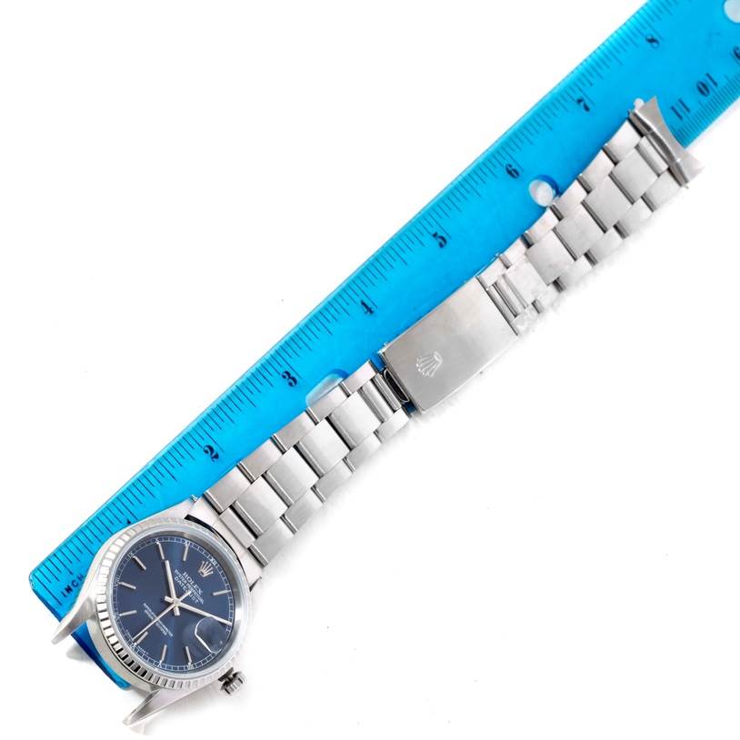 The image shows the full length of a Rolex Datejust 16220 Men
s Stainless Steel Blue Dial 16220 Men
s Stainless Steel Blue Dial watch, including the face, bracelet, and clasp, with a ruler for scale.