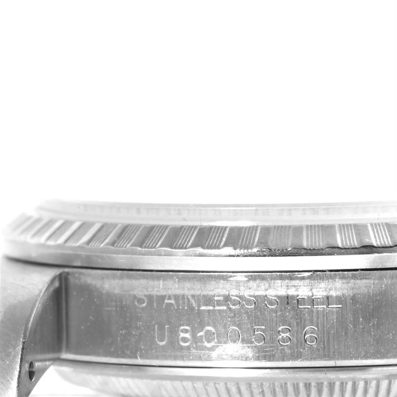 The image shows a side view of the Rolex Datejust 16220 Men
s Stainless Steel Blue Dial 16220 Men
s Stainless Steel Blue Dial watch, focusing on the stainless steel casing and the serial number.