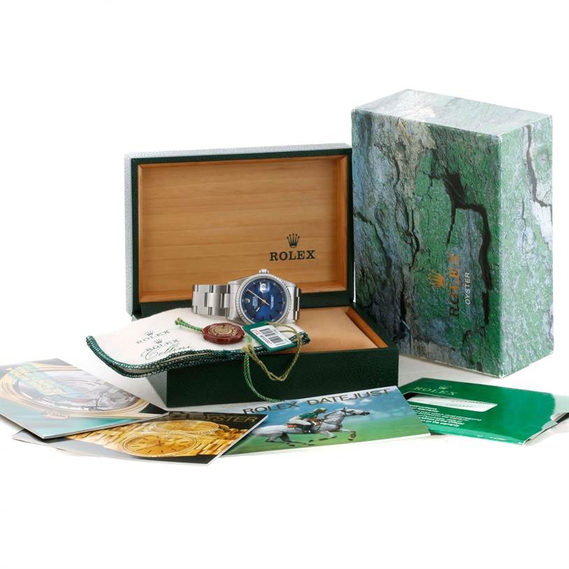 The Rolex Datejust 16220 Men
s Stainless Steel Blue Dial 16220 Men
s Stainless Steel Blue Dial watch is shown with its box, booklet, tags, and accessories in a front angle view.