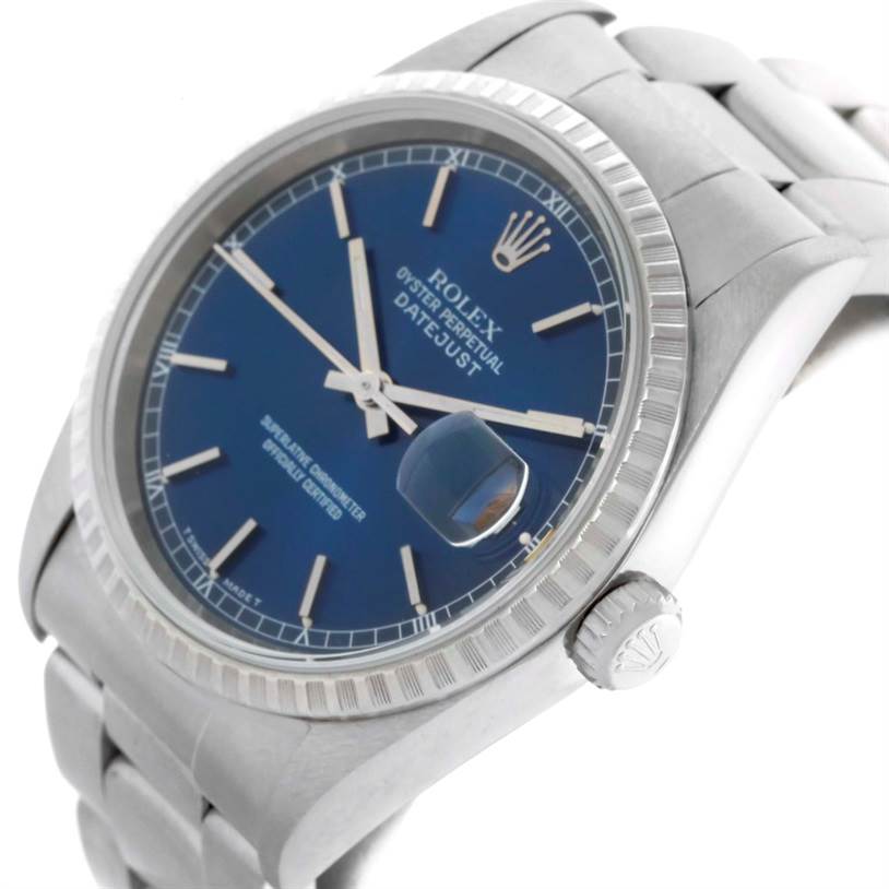 The image shows a Rolex Datejust 16220 Men
s Stainless Steel Blue Dial 16220 Men
s Stainless Steel Blue Dial watch at a three-quarter angle, highlighting its blue dial, fluted bezel, Cyclops lens, and bracelet.