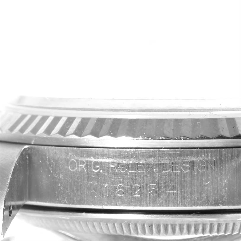 The image shows a close-up side angle of a Rolex Datejust 16234 Men's Stainless Steel White Dial 16234 Men's Stainless Steel White Dial watch, highlighting its fluted bezel and part of the case with an engraved serial number.