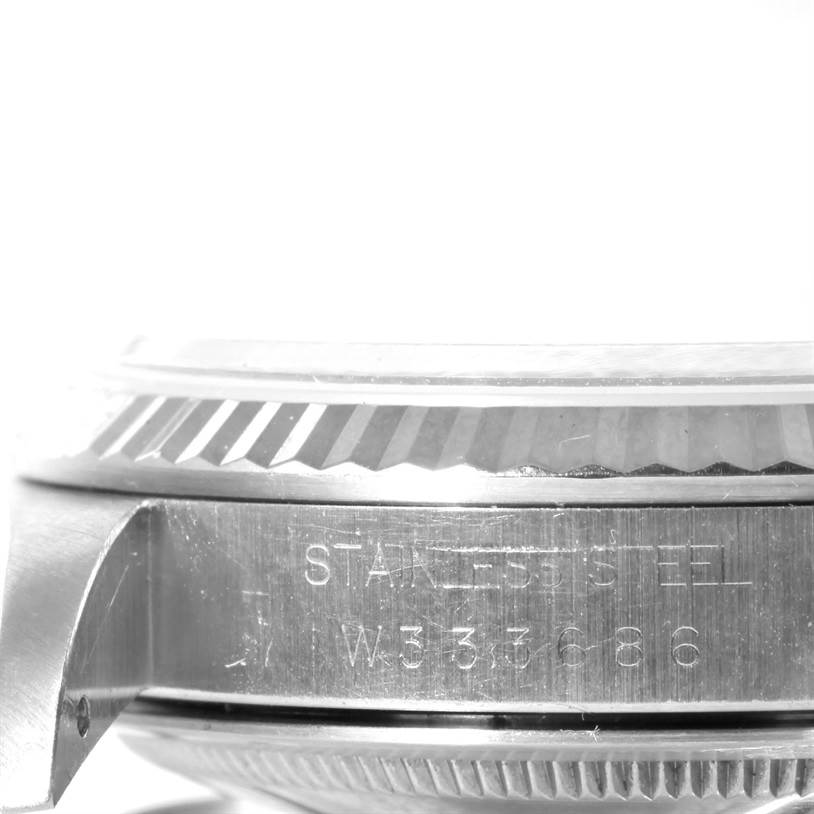 This image shows a close-up of the side of the Rolex Datejust 16234 Men's Stainless Steel White Dial 16234 Men's Stainless Steel White Dial watch, highlighting the fluted bezel and part of the case with engraving.