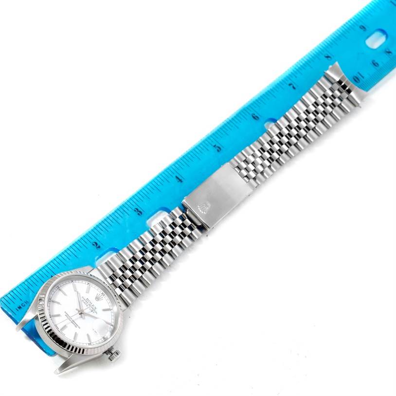 The image shows a Rolex Datejust 16234 Men's Stainless Steel White Dial 16234 Men's Stainless Steel White Dial watch lying flat, alongside a ruler, displaying its face and entire bracelet.