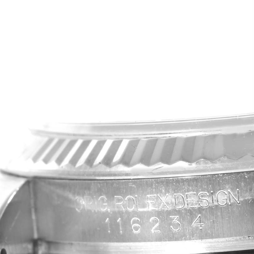 The angle shows a close-up of the bezel and part of the casing with "ORIG. ROLEX DESIGN 116234" engraved on the Rolex Datejust 116234 Men's Stainless Steel Silver Dial 116234 Men's Stainless Steel Silver Dial watch.