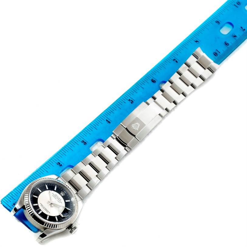 This image shows a Rolex Datejust 116234 Men's Stainless Steel Silver Dial 116234 Men's Stainless Steel Silver Dial watch laid flat beside a blue ruler, highlighting its bracelet and clasp.