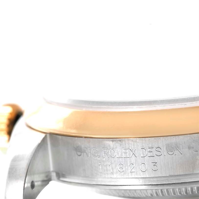 The image shows a close-up angle of the Rolex Datejust 116203 Men
s Stainless Steel White Dial 116203 Men
s Stainless Steel White Dial watch case with "ORIG. ROLEX DESIGN" and the model number engraved.