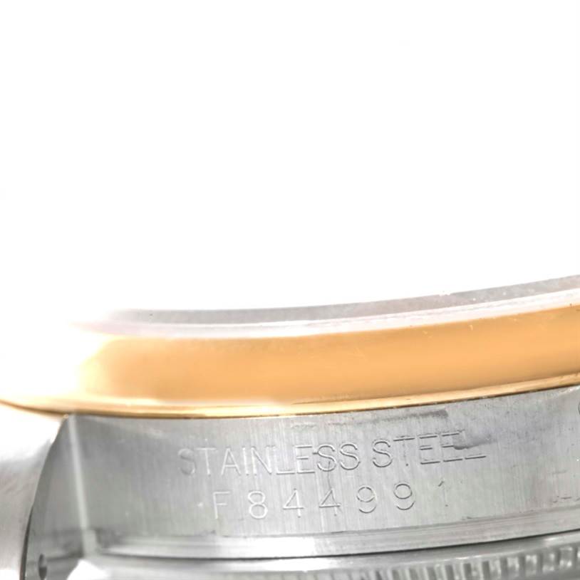 The image shows a close-up of the bezel and case of a Rolex Datejust 116203 Men
s Stainless Steel White Dial 116203 Men
s Stainless Steel White Dial watch, highlighting its stainless steel part with engravings.