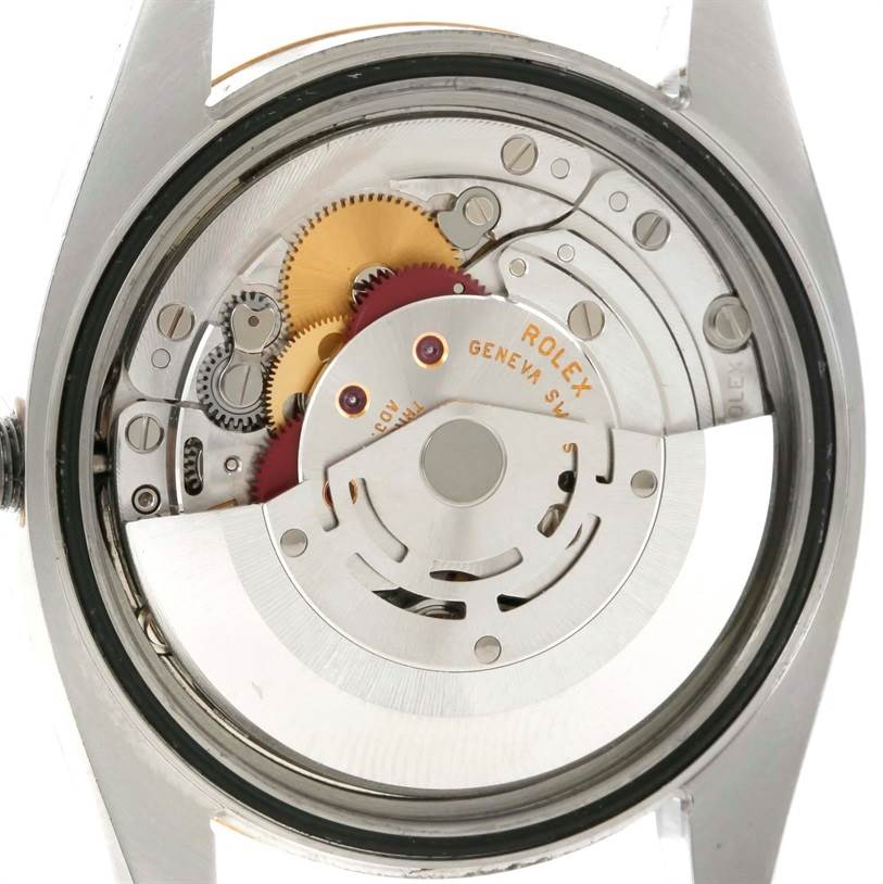 The image shows the back view of a Rolex Datejust 116203 Men
s Stainless Steel White Dial 116203 Men
s Stainless Steel White Dial watch, highlighting its movement and internal mechanics.