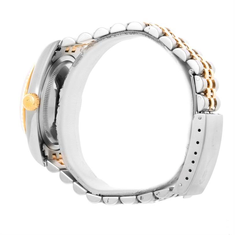 The Rolex Datejust 16233 Men's Steel and Gold (two tone) Silver Dial 16233 Men's Steel and Gold (two tone) Silver Dial watch is shown from a side angle highlighting its case, crown, and bracelet.