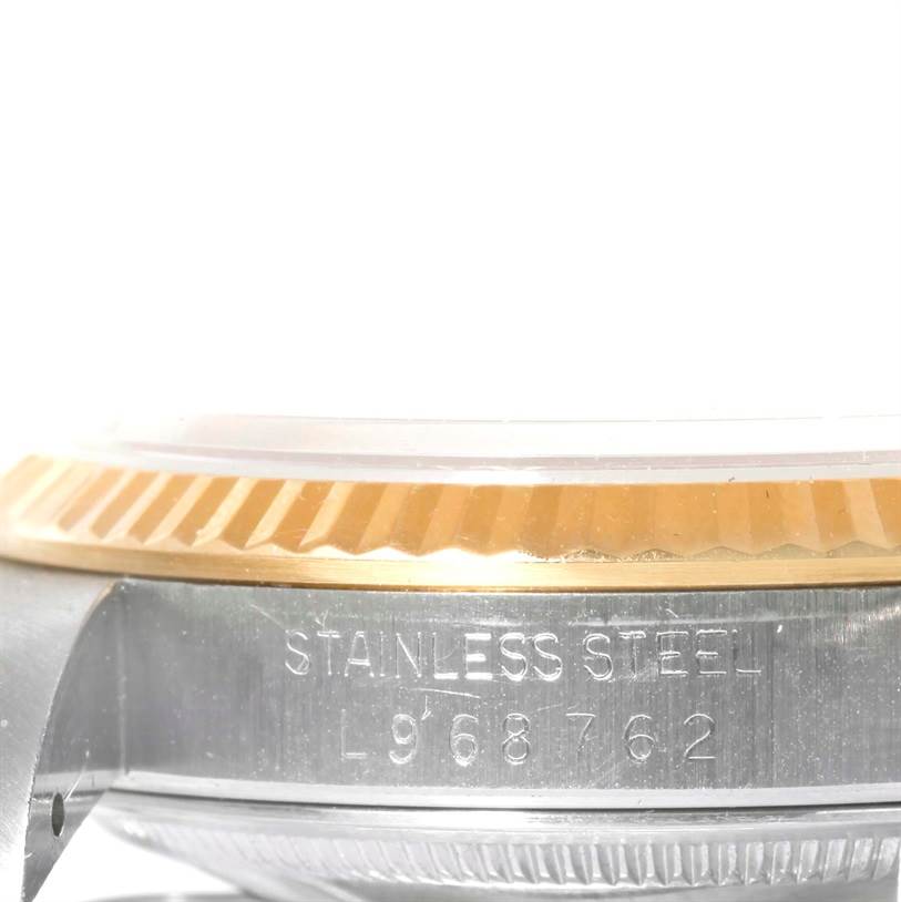 This image shows a side view of a Rolex Datejust 16233 Men's Steel and Gold (two tone) Black Dial 16233 Men's Steel and Gold (two tone) Black Dial watch case, highlighting the fluted bezel and engraved serial number.