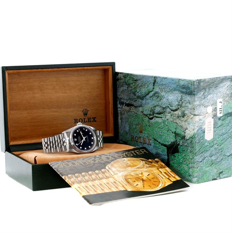 The image shows a Rolex Datejust 16234 Men
s Stainless Steel Black Dial 16234 Men
s Stainless Steel Black Dial watch placed in an open wooden box, with an instruction manual and outer box visible.