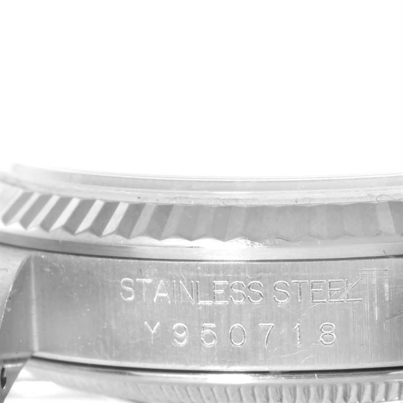 The image shows a close-up of the side view of a Rolex Datejust 16234 Men's Stainless Steel White Dial 16234 Men's Stainless Steel White Dial watch, highlighting its bezel and engraved serial number.