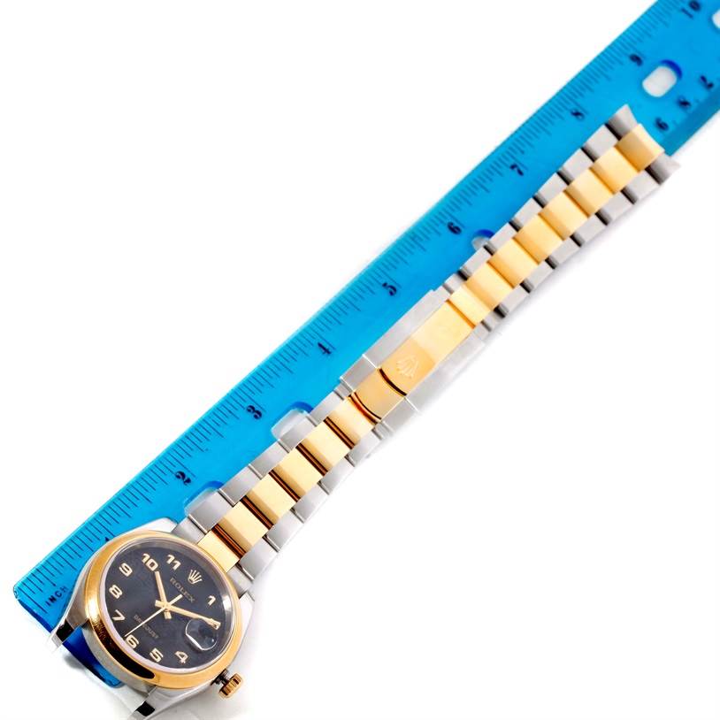 The image shows a top-down view of a Rolex Datejust 116203 Men's Stainless Steel Black Dial 116203 Men's Stainless Steel Black Dial watch, highlighting its two-tone bracelet and dial placed next to a blue ruler.