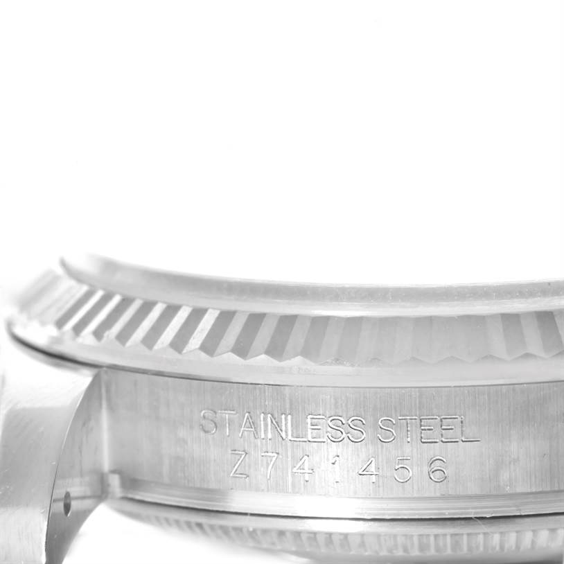 The image shows a close-up side view of the stainless steel case and fluted bezel of a Rolex Datejust 116234 Men's Stainless Steel White Dial 116234 Men's Stainless Steel White Dial watch.