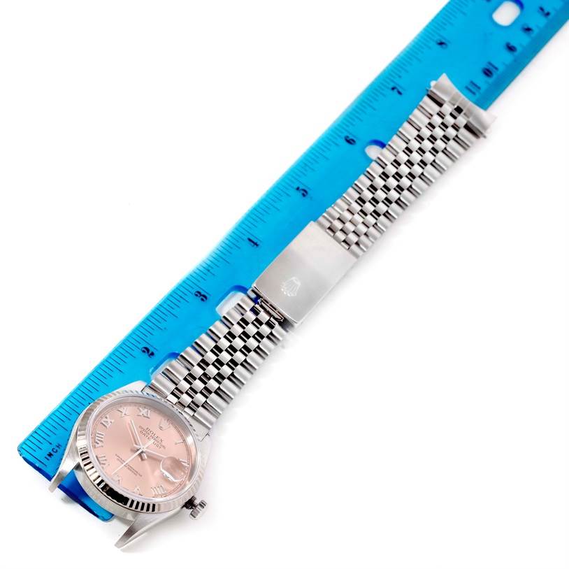 This image shows the Rolex Datejust 16234 Men
s Stainless Steel Pink Dial 16234 Men
s Stainless Steel Pink Dial watch lying flat with a blue ruler, displaying the face, bracelet, and clasp from a top view.